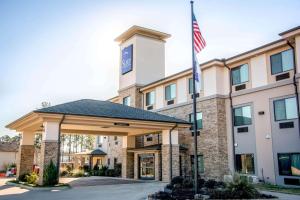 una imagen de la parte delantera de un hotel con bandera americana en Sleep Inn & Suites Center, en Center