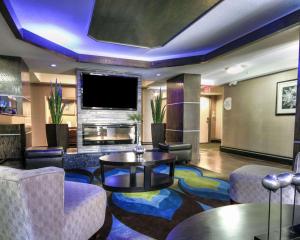 a hotel lobby with a tv and a table and chairs at Comfort Inn & Suites I-10 Airport in El Paso