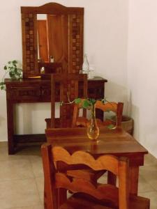 a table and chairs with a desk and a vase on it at Hotel Real Colonial in Valladolid
