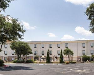 un grand bâtiment blanc avec un parking dans l'établissement Comfort Inn & Suites Burnet, à Burnet