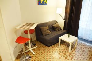 uma pequena sala de estar com um sofá e uma mesa em Studio charmant intra-muros em Avignon