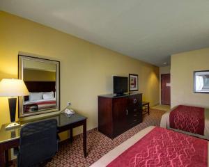 um quarto de hotel com um quarto com uma cama e uma secretária em Comfort Inn & Suites Donna near I-2 em Donna