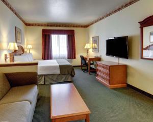 Cette chambre comprend un lit et une télévision à écran plat. dans l'établissement Quality Inn & Suites - Glen Rose, à Glen Rose
