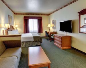 a hotel room with a bed and a flat screen tv at Quality Inn & Suites - Glen Rose in Glen Rose