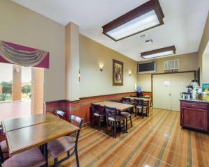 a dining room with tables and chairs and a kitchen at Econo Lodge Inn & Suites in Eagle Pass
