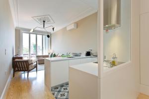 a kitchen with white counters and a dining room at Soulmade Porto in Porto