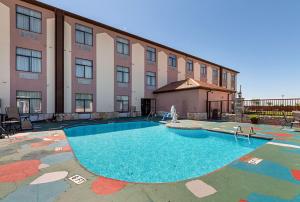 a building with a swimming pool in front of a building at Quality Inn & Suites Buda in Buda