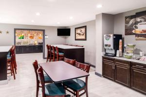 a kitchen and dining room with a table and chairs at Quality Inn & Suites Plano East - Richardson in Plano