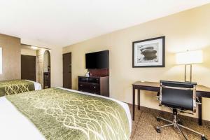 a hotel room with a bed and a desk and a chair at Comfort Inn Dallas Park Central in Dallas