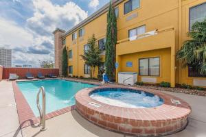 a swimming pool in front of a building at Comfort Inn Dallas Park Central in Dallas