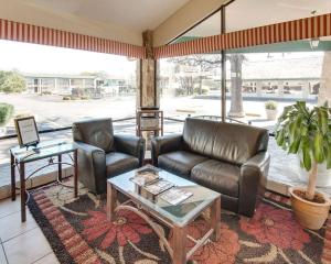 un soggiorno con divano e tavolo di Days Inn by Wyndham Gatesville a Gatesville