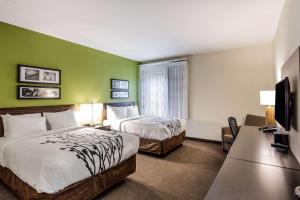a hotel room with two beds and a television at Sleep Inn Dallas Love Field-Medical District in Dallas +25 photos