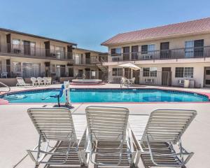 a swimming pool with lounge chairs and a swimming pool at Econo Lodge St George North - Near Pioneer Park in St. George