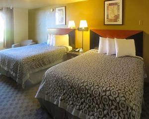 Postel nebo postele na pokoji v ubytování Rose City Inn & Suites