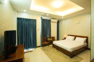 a bedroom with a bed and a television in it at Ben Thanh Retreats Hotel in Ho Chi Minh City