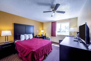 a hotel room with a bed and a flat screen tv at Rodeway Inn & Suites Monticello in Monticello