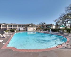 a large swimming pool with chairs and a building at Days Inn by Wyndham Gatesville in Gatesville