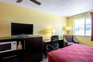 a hotel room with a bed and a flat screen tv at Rodeway Inn & Suites in Monticello