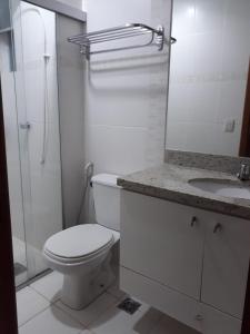 a bathroom with a toilet and a shower and a sink at Veredas do Rio Quente 215 in Rio Quente