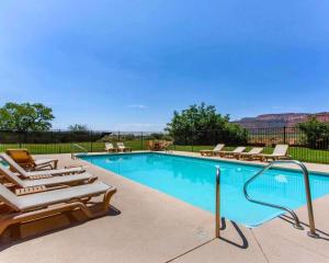 a swimming pool with chaise lounge chairs and a pool at Rodeway Inn Kanab - National Park Area in Kanab
