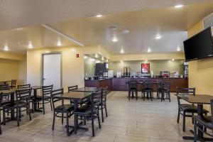a dining room with tables and chairs and a kitchen at Econo Lodge Hurricane Zion Park Area in Hurricane