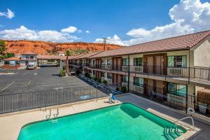 a pool in front of a building with a parking lot at Rodeway Inn St George North - Near Pioneer Park in St. George