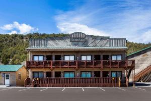 un grand bâtiment en bois avec une terrasse sur un parking dans l'établissement Quality Inn Bryce Canyon, à Panguitch