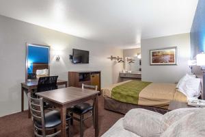 une chambre d'hôtel avec un lit, une table et un canapé dans l'établissement Rodeway Inn St George North - Near Pioneer Park, à Saint George