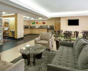 Quality Inn Richmond Airport في ساندستون: غرفة معيشة مع أريكة وكراسي وطاولة