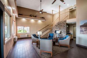a lobby with chairs and a staircase with a stair case at Comfort Inn Green River National Park Area in Green River