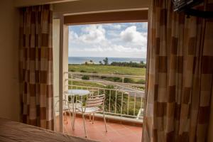 een balkon met een tafel en stoelen en uitzicht op de oceaan bij Areia Dourada in Porto Santo