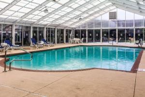 a large swimming pool with chairs and a building at Sleep Inn Lake Wright - Norfolk Airport in Norfolk