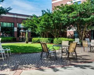 a patio with chairs and a table in front of a building at Quality Suites Lake Wright - Norfolk Airport in Norfolk