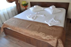 a bed with a white comforter and pillows at Ave Hotel Victoriei in Bucharest