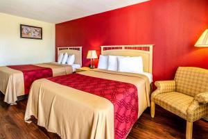 a hotel room with two beds and a chair at Econo Lodge Christiansburg-Blacksburg I-81 in Christiansburg