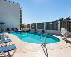una piscina con 2 sillas y un edificio en Ocean27 Hotel, en Virginia Beach