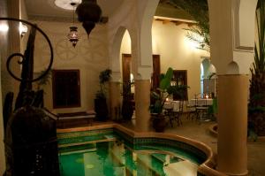 a house with a swimming pool in a room at Riad Les Trois Palmiers El Bacha in Marrakech