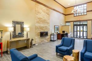 a waiting room with blue chairs and a fireplace at Comfort Inn Woodstock Shenandoah in Woodstock