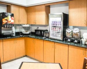 a kitchen with wooden cabinets and a refrigerator at Sleep Inn & Suites Stony Creek - Petersburg South in Stony Creek