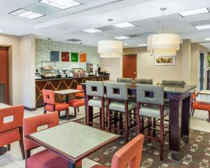 a restaurant with tables and chairs and a kitchen at Comfort Inn Near Quantico Main Gate North in Dumfries