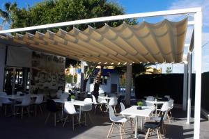 a patio with tables and chairs under a canopy at Camping Tauro in Benicàssim