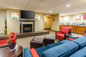 a waiting room with blue couches and a fireplace at Comfort Suites in Wytheville