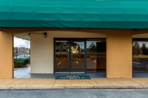 a store front with a green awning and windows at Quality Inn in Culpeper