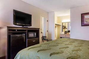 a hotel room with a bed and a flat screen tv at Quality Inn Culpeper in Culpeper