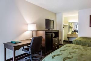 Habitación de hotel con escritorio, TV y cama en Quality Inn Culpeper, en Culpeper