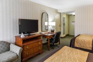 a hotel room with a desk with a television and a bed at Comfort Inn Pentagon City in Arlington