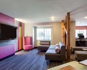 a living room with a couch and a flat screen tv at Quality Inn & Suites Ashland near Kings Dominion in Ashland