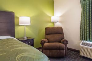 a hotel room with a bed and a chair at Quality Inn in Culpeper