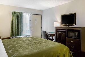 a hotel room with a bed and a flat screen tv at Quality Inn in Culpeper