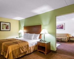 a hotel room with a bed, desk and a lamp at MainStay Suites Williamsburg I-64 in Williamsburg